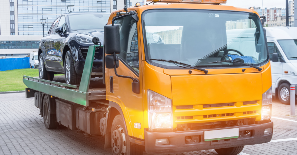 A scrap vehicle loaded on the back of a flatbed