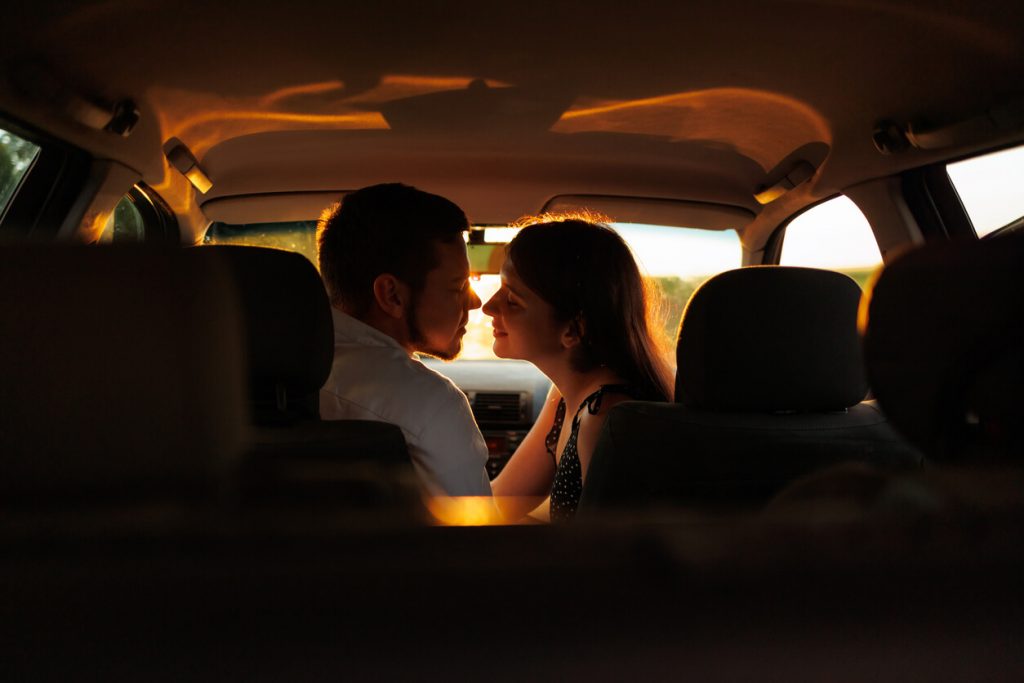 Couple sitting in a car about to kiss